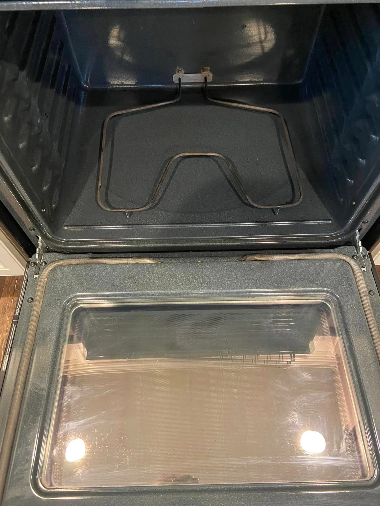 After cleaning: the same oven interior and glass door cleared of baked-on residue