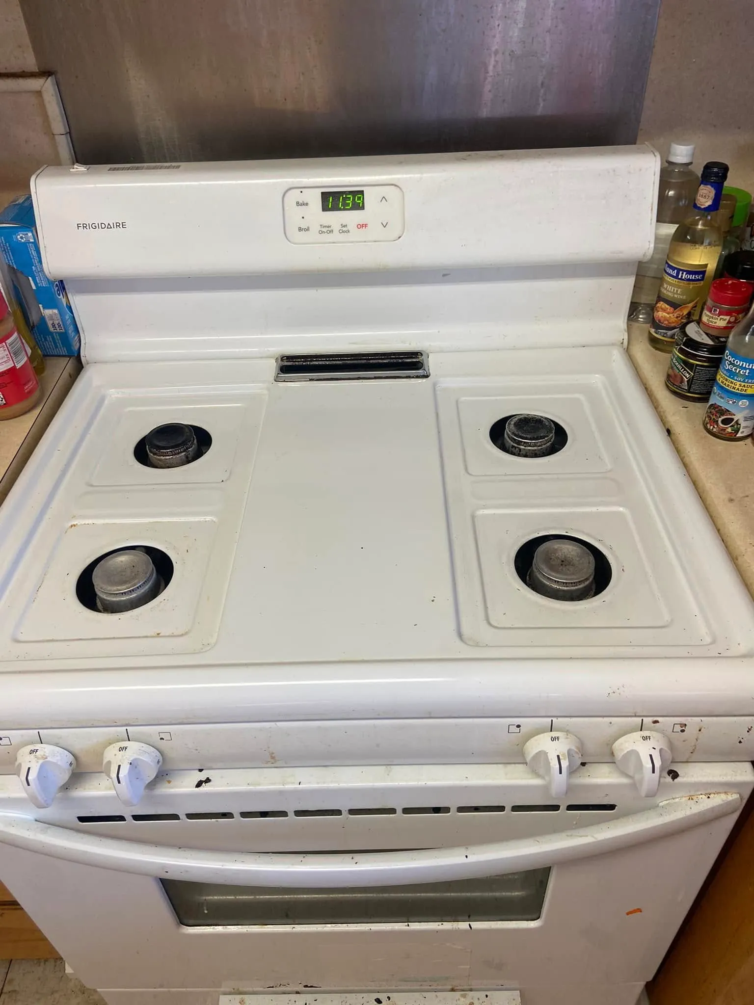 After cleaning: the same white electric stovetop with clean burners and surface