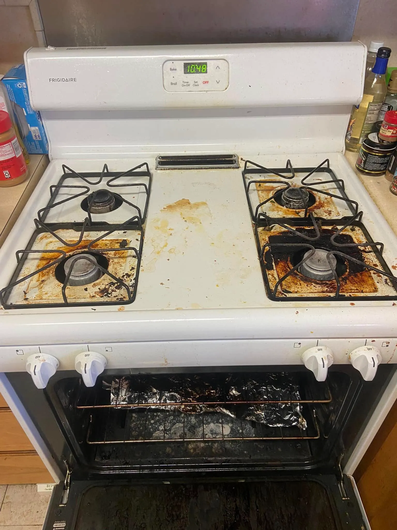 Before cleaning: cooking residue around a white electric stovetop’s burners